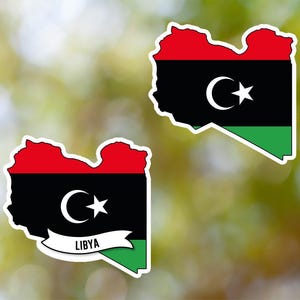 Peut inclure: Deux autocollants représentant le drapeau libyen. Le drapeau est vert, noir et rouge avec un croissant de lune blanc et une étoile. L'autocollant du haut ne comporte aucun texte. L'autocollant du bas comporte le mot "LIBYA" écrit en blanc sur une bannière blanche.