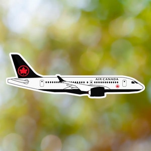 Puede incluir: Un avión blanco y negro de Air Canada con un logotipo de hoja de arce roja en la cola. El avión está en vuelo.