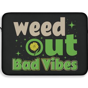 May include: Black laptop sleeve with the text "weed out bad vibes" in green and beige lettering. A yellow flower is inside a green circle.