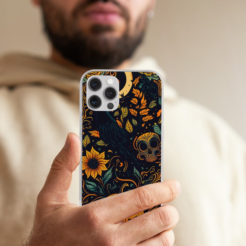 May include: A black phone case with a floral design featuring sunflowers, leaves, a raven, and a skull. The case has a clear background and a black and white design.