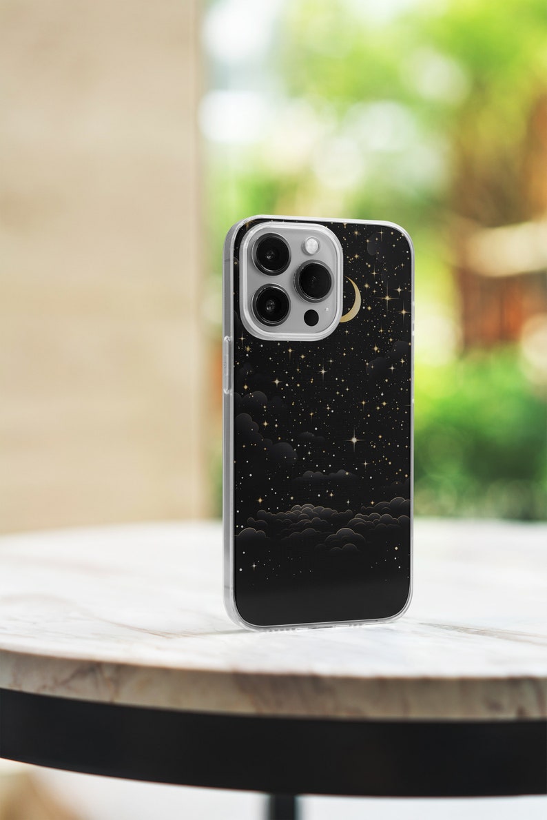 May include: A clear phone case with a black background and a gold crescent moon and stars design.
