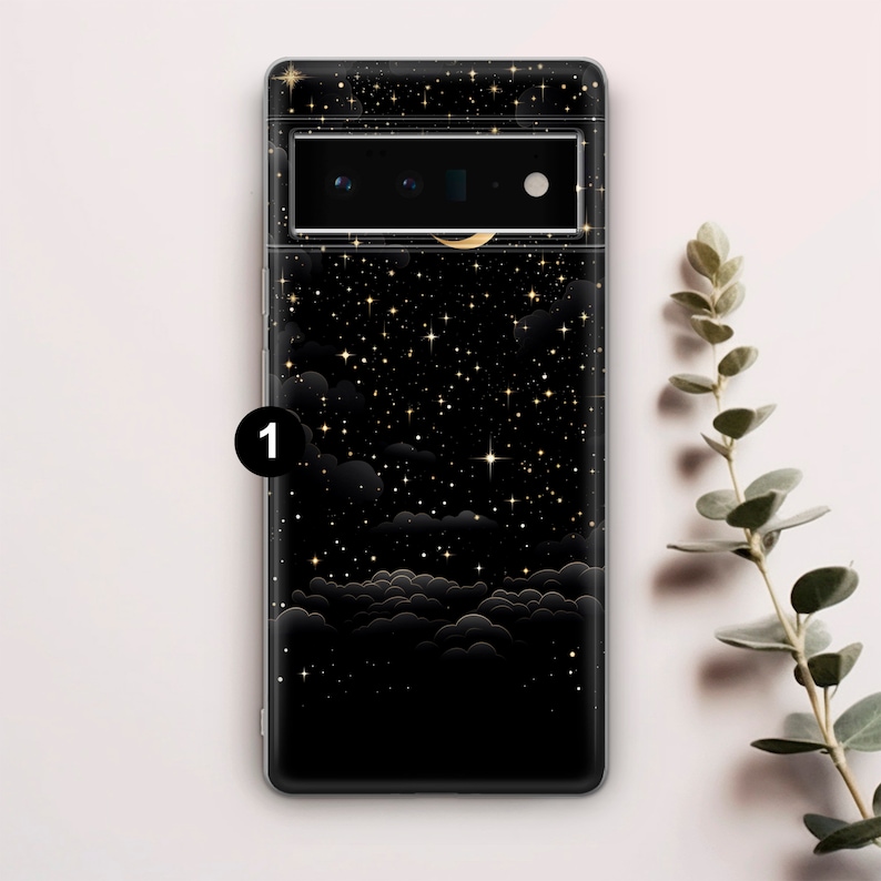 Puede incluir: Una funda de tel&eacute;fono negra con un dise&ntilde;o de noche estrellada. La funda presenta una luna creciente y estrellas doradas sobre un fondo negro.
