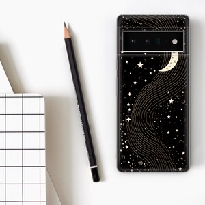 Puede incluir: Carcasa de tel&eacute;fono negra con un dise&ntilde;o de media luna y estrellas doradas sobre un fondo negro.
