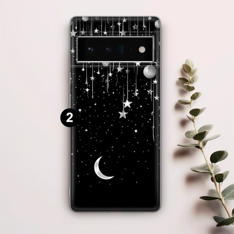 Puede incluir: Carcasa de tel&eacute;fono negra con un dise&ntilde;o de luna creciente y estrellas. La carcasa tiene una parte posterior transparente y un borde negro.