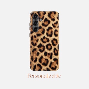 May include: A rectangular smartphone case featuring a brown, black, and tan leopard print pattern across the entire back surface. The case includes a vertical camera cutout with three circular lenses and a flash. The word Personalizable is printed below.