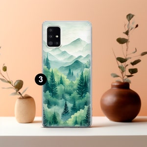 May include: A clear phone case featuring a watercolor landscape of green trees and mountains. The design has a soft, blurred effect, with varying shades of green and a light, airy feel. The number "3" is visible on the case.