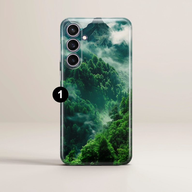 May include: A phone case with a green and white mountain landscape design. The case has a clear back and a black camera bump with three lenses.