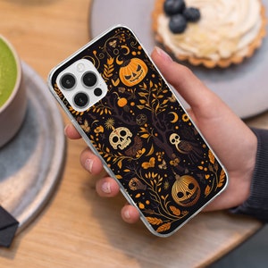 May include: A black phone case with a Halloween-themed design. The case features a black background with orange, yellow, and white pumpkins, skulls, and leaves. The case also has a camera lens cutout and a cutout for the phone's charging port.