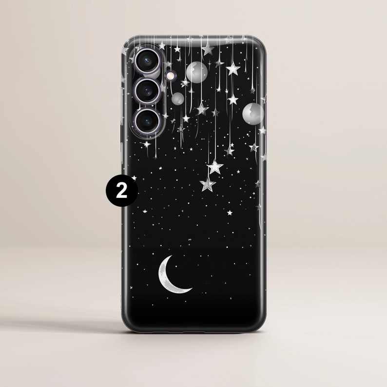 May include: A clear phone case with a black background and a design of white stars, a crescent moon, and planets. The case has a cutout for a triple camera lens.
