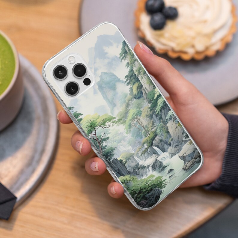 a person holding a phone with a painting on it