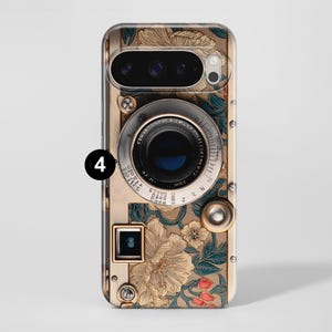 Pu&ograve; includere: Una custodia per telefono con un design di fotocamera vintage. La custodia presenta un motivo dorato e floreale con un obiettivo e pulsanti della fotocamera. Il design include un obiettivo, pulsanti e un flash, con il numero 4 in un cerchio nero.
