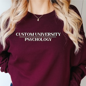 May include: A maroon sweatshirt with the text "CUSTOM UNIVERSITY PSYCHOLOGY" in white.