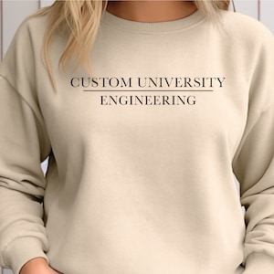 May include: A beige sweatshirt with the text "CUSTOM UNIVERSITY ENGINEERING" printed on the front.