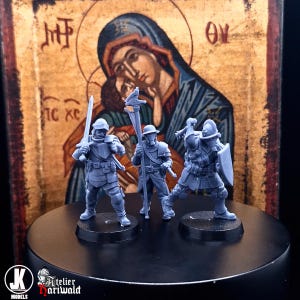 Può includere: Tre figurine grigie in miniatura di soldati in armatura, ognuna con un'arma o un bastone, sono su basi nere. Lo sfondo presenta un'icona religiosa con una raffigurazione di Maria e Gesù.