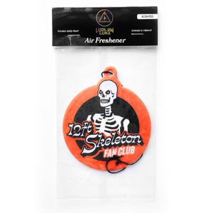 May include: Orange and black air freshener with a skeleton graphic. The air freshener is round and features the text "12ft Skeleton Fan Club" and "Ludlow Luna Air Freshener". The air freshener is double-sided and scented.