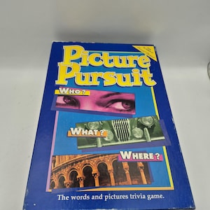 Puede incluir: Una caja de juego de mesa azul titulada "Picture Pursuit" con texto amarillo y blanco. La caja presenta imágenes y las preguntas "WHO?", "WHAT?" y "WHERE?". El texto "The words and pictures trivia game" está en la parte inferior.
