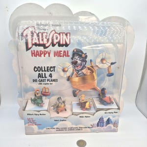 Peut inclure: Un ensemble de jouets Happy Meal McDonald's mettant en vedette Disney's TaleSpin. L'emballage comprend quatre avions moulés sous pression : Wildcat's Flying Machine, Baloo's Seaplane, Molly's Biplane et Kit's Racing Plane. L'image principale montre Baloo dans un avion.
