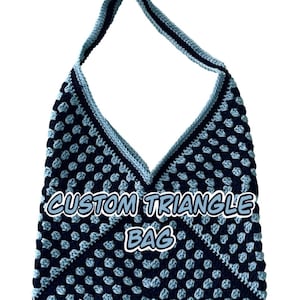 May include: A handmade, crocheted triangle bag in navy blue and light blue. The bag features a unique pattern and a strap for carrying. The text "CUSTOM TRIANGLE BAG" is displayed on the front of the bag.