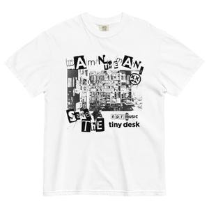 Puede incluir: Camiseta blanca con un gráfico en blanco y negro. El gráfico presenta el texto "Damn the Man, Save the Tiny Desk" con una imagen de una estantería y el logotipo de NPR Music.