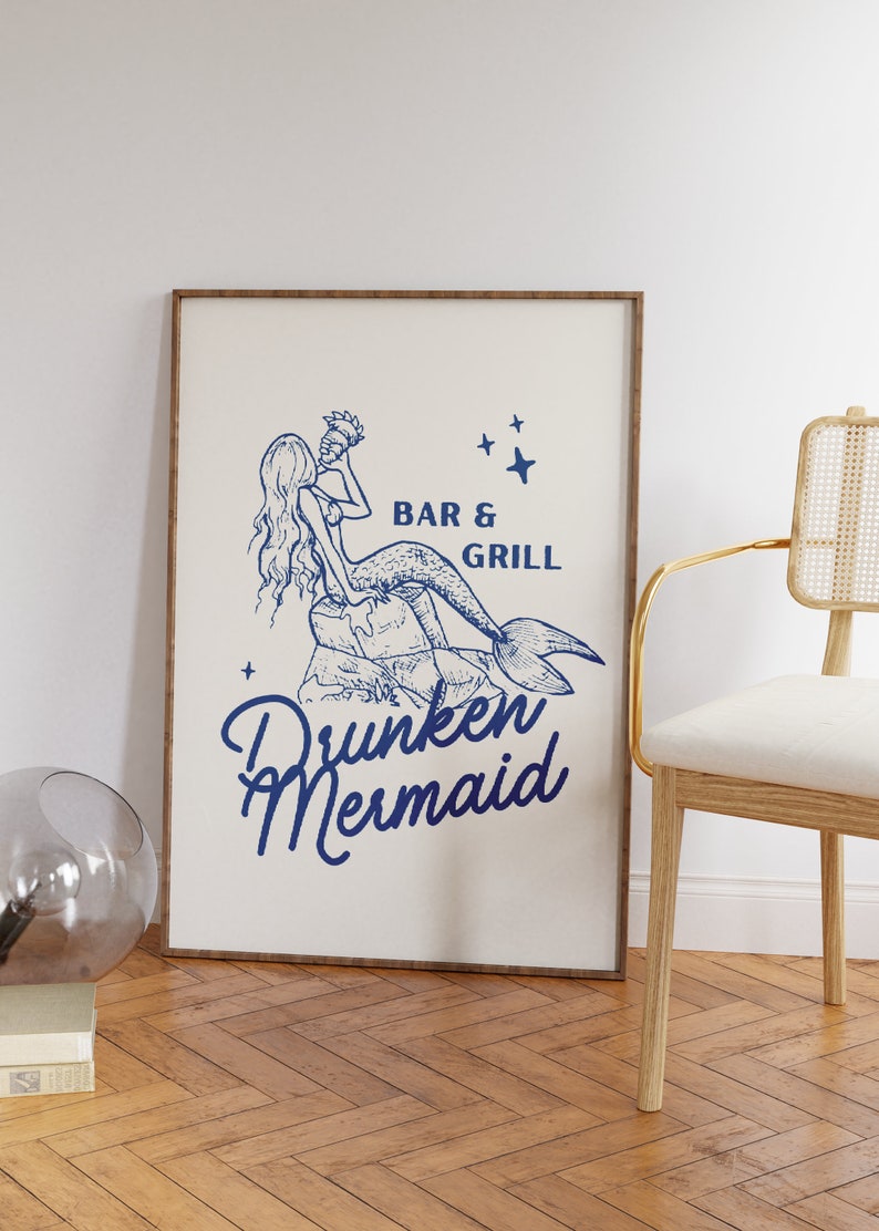 May include: A framed print with a blue illustration of a mermaid holding a seashell. The text "Bar & Grill" and "Drunken Mermaid" are below the illustration.