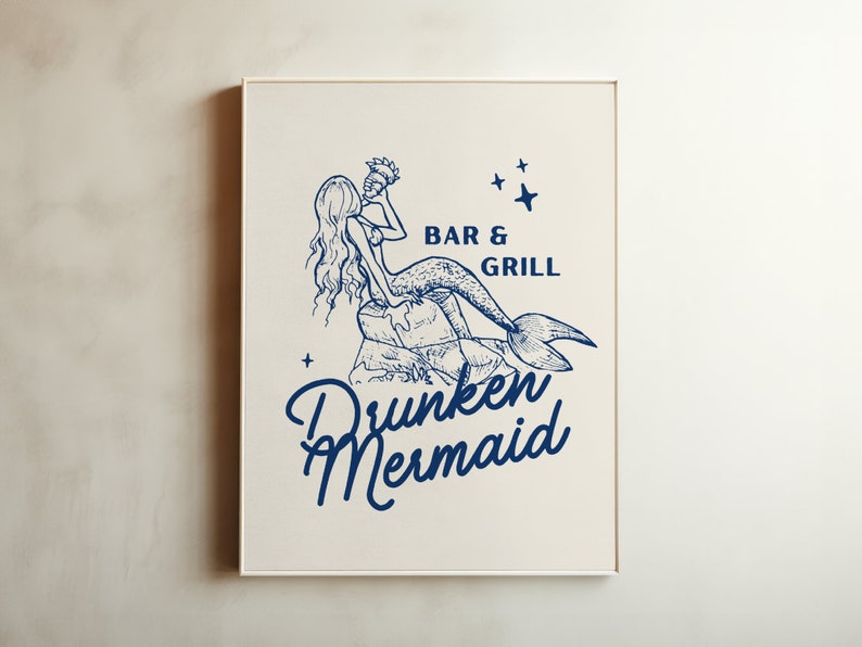 May include: A white framed print with a blue illustration of a mermaid holding a seashell. The text "BAR & GRILL" and "Drunken Mermaid" is printed below the illustration.