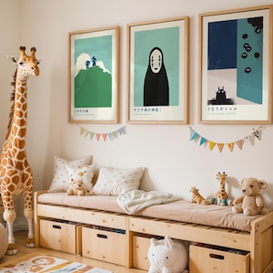 A giraffe statue stands next to a wooden bench with stuffed animals and toys, and three framed posters on the wall above it.