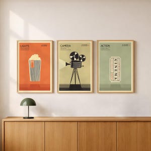 Op de afbeelding: Drie ingelijste wandposters met filmthema's. De linker poster is oranje met een bak popcorn, de middelste poster is beige met een vintage filmcamera op een statief en de rechter poster is saliegroen met een afbeelding van een bioscoopkaartje.