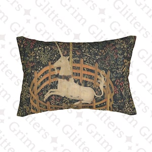 May include: Rectangular pillow featuring a tapestry design with a white unicorn inside a wooden fence. The background is a dark floral pattern with red and green accents. The pillow has a vintage aesthetic.