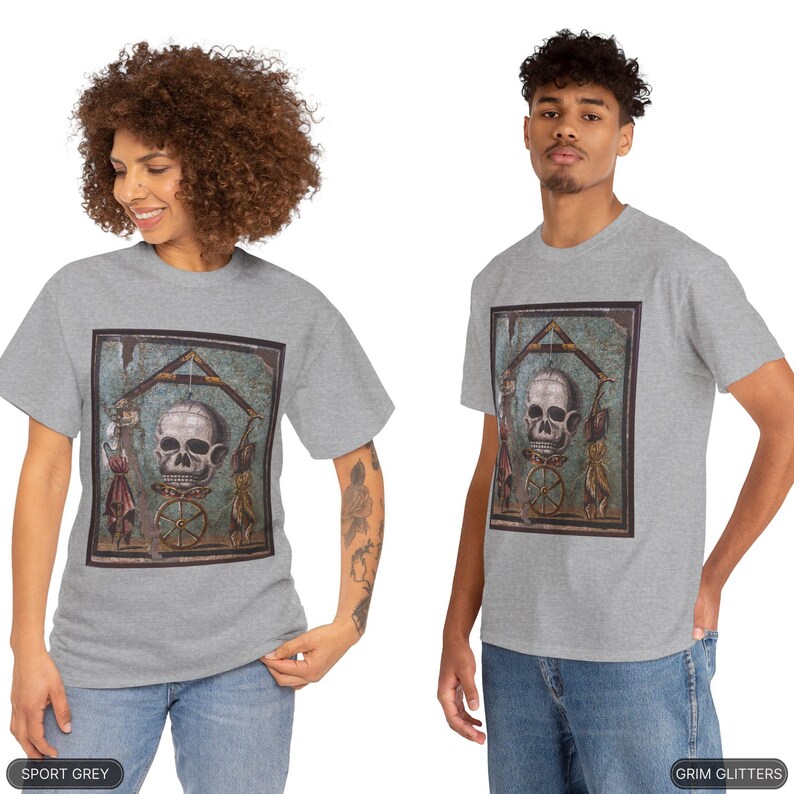 May include: A gray t-shirt with a print of a skull and bones in a frame. The skull is white and the bones are black. The frame is brown and has a green background. The t-shirt is available in sport grey.
