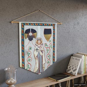 May include: A medieval-style tapestry featuring a white-robed figure with a cross on their chest, a black and gold shield, and a decorative design of vines and leaves. The tapestry is framed with a red, blue, and gold border.