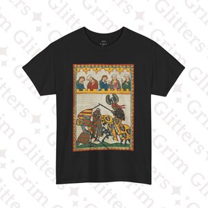 May include: Black t-shirt with a vintage illustration of a medieval jousting scene. Two knights on horseback are facing each other with lances raised. The scene is framed by a yellow and red border.