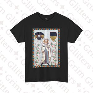 May include: Black t-shirt with a colorful illustration of a person in medieval clothing. The illustration is framed with a red, blue, and gold border.