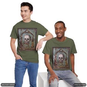 May include: Two men wearing olive green t-shirts with a graphic print of a skull in a mosaic frame. The text "Grim Glitters" is printed on the bottom right of the image. The text "Military Green" is printed on the bottom left of the image.
