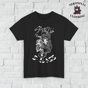 May include: Black t-shirt with a white graphic of a tiger in clouds with the text "Stray Kids" and "S-Class" printed on it.