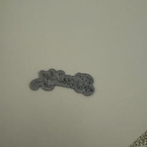 May include: A gray felt bone-shaped dog toy.
