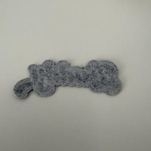 May include: A gray felt patch with the word "Grandma" written in white.