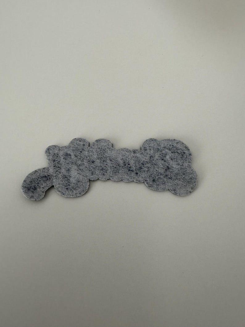 May include: A gray felt patch with the word "Grandma" written in white.