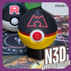 Puede incluir: Una Pok&eacute; Ball Pokemon impresa en 3D de color negro, amarillo y rojo con un s&iacute;mbolo de monta&ntilde;a y el texto "N3D APPROVED SELLER".