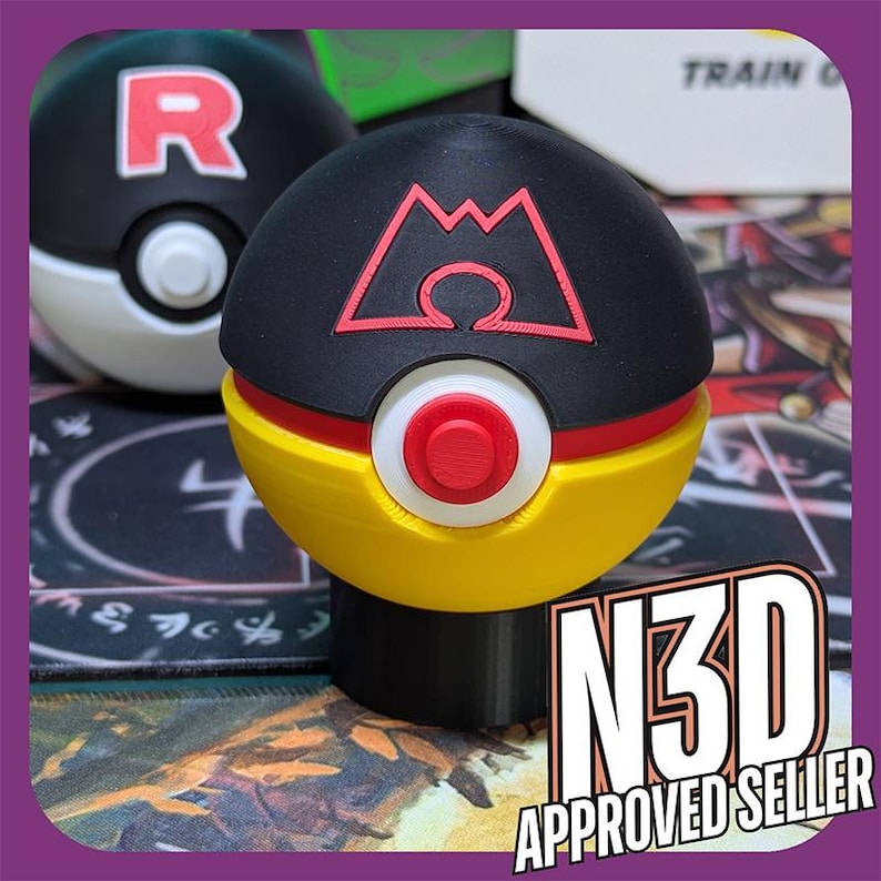 Puede incluir: Una Pok&eacute; Ball Pokemon impresa en 3D de color negro, amarillo y rojo con un s&iacute;mbolo de monta&ntilde;a y el texto "N3D APPROVED SELLER".