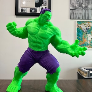 May include: A green and purple Hulk action figure with a detailed muscular body and a fierce expression. The figure is posed in a dynamic stance with one arm raised and the other extended.