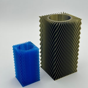 May include: Two 3D printed cylindrical vases, one blue and one gold, with a textured, wavy design.
