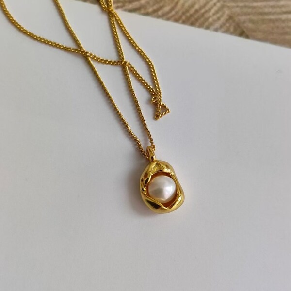 This necklace showcases a combination of luxurious elements, with an 18k gold pendant suspended from a pure silver chain