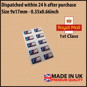 May include: Ten blue, red and white BMW car logo stickers on a white sheet of paper. The stickers are 0.35 by 0.66 inches. The text "Royal Mail 1st Class" is in the top right corner of the image.