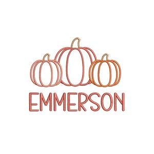 Puede incluir: Un diseño de bordado que presenta tres calabazas delineadas en tonos naranja y coral, dispuestas en fila. Debajo de las calabazas, el nombre EMMERSON está bordado en una fuente sans-serif de letras mayúsculas en color coral a juego.