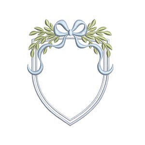 May include: A decorative shield-shaped design with a light blue bow and ribbons, and green leaves. The frame is outlined in a light gray color. The design is suitable for embroidery or crafting projects.
