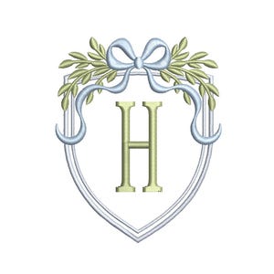 May include: Embroidered design featuring a shield shape with a light blue bow and ribbons, olive green leaves, and the letter "H" in a gold color. The design is on a white background.