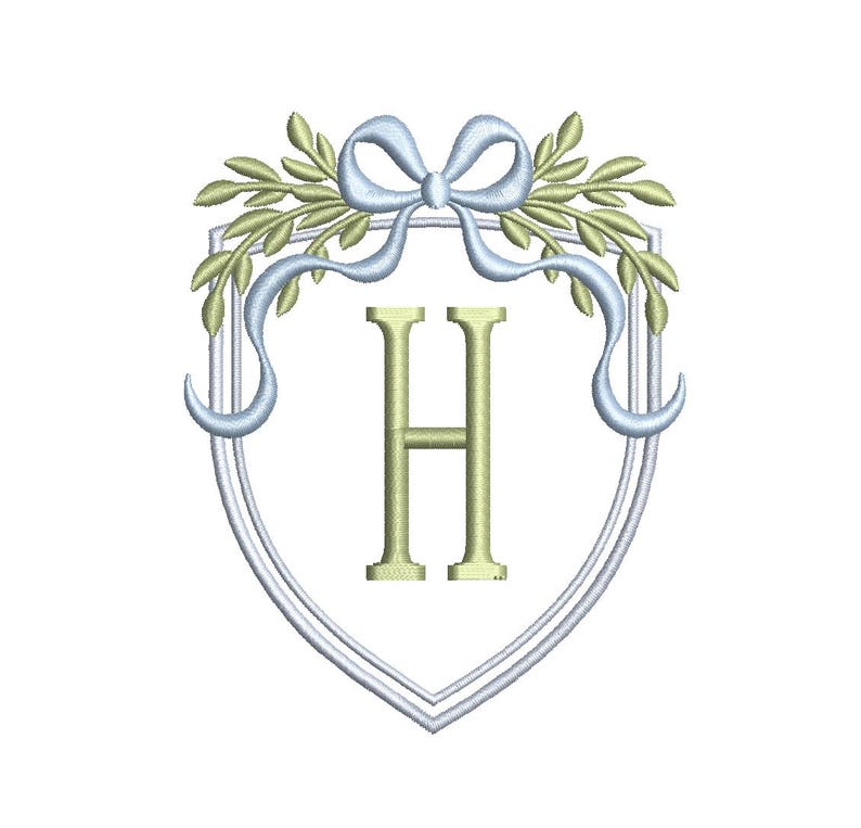 May include: Embroidered design featuring a shield shape with a light blue bow and ribbons, olive green leaves, and the letter "H" in a gold color. The design is on a white background.
