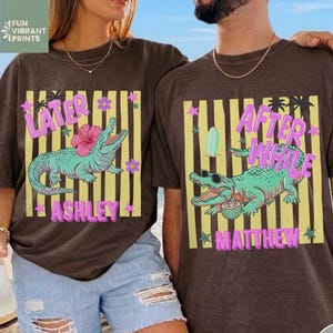Peut inclure: Deux t-shirts bruns avec des motifs assortis. L'un dit "Later Ashley" avec un motif d'alligator, l'autre dit "After While Matthew" avec un motif d'alligator similaire. Les deux chemises ont des fonds rayés jaunes et blancs.