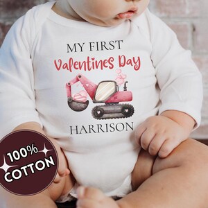 May include: A white ceramic mug with a black handle and the text "But First, Coffee" in a bold, black font. The mug is set against a blurred background, suggesting a cozy setting.