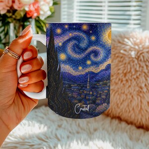 May include: A white ceramic mug featuring a vibrant, detailed reproduction of Vincent van Gogh's The Starry Night painting. The design includes a dark cypress tree, a swirling night sky with yellow stars, and a village. The name Cristal is printed.